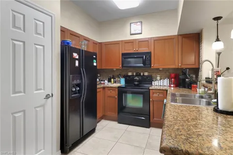 a kitchen with stainless steel appliances granite countertop a refrigerator and a stove top oven