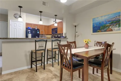 a view of a dining room and livingroom with furniture wooden floor a rug a painting and a chandelier