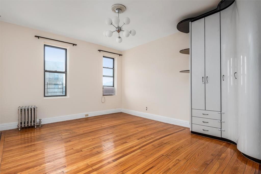 2425 Kings Highway, Unit E16 Brooklyn, NY 11229 - Photo 9 of 11 a view of an empty room with wooden floor and a window