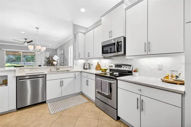 a kitchen with stainless steel appliances a refrigerator a stove a dining table and chairs with wooden floor