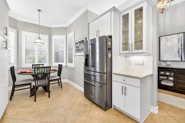 a dining room with furniture a large window and potted plants