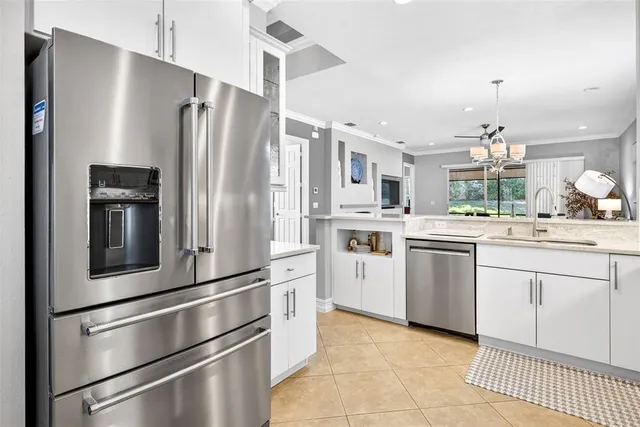 a kitchen with stainless steel appliances granite countertop a refrigerator a stove and a sink