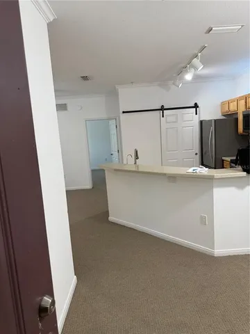 a view of a kitchen with refrigerator and white cabinets