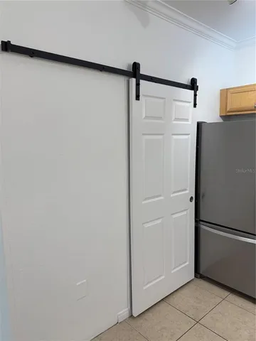 a view of a refrigerator in kitchen and white cabinets