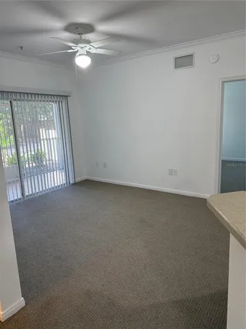 an empty room with windows and fan