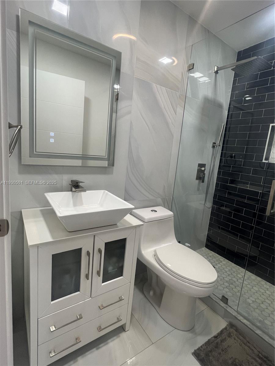 6101 Southwest 153rd Court Road Miami, FL 33193 - Photo 29 of 49 a bathroom with a sink a toilet a mirror and shower