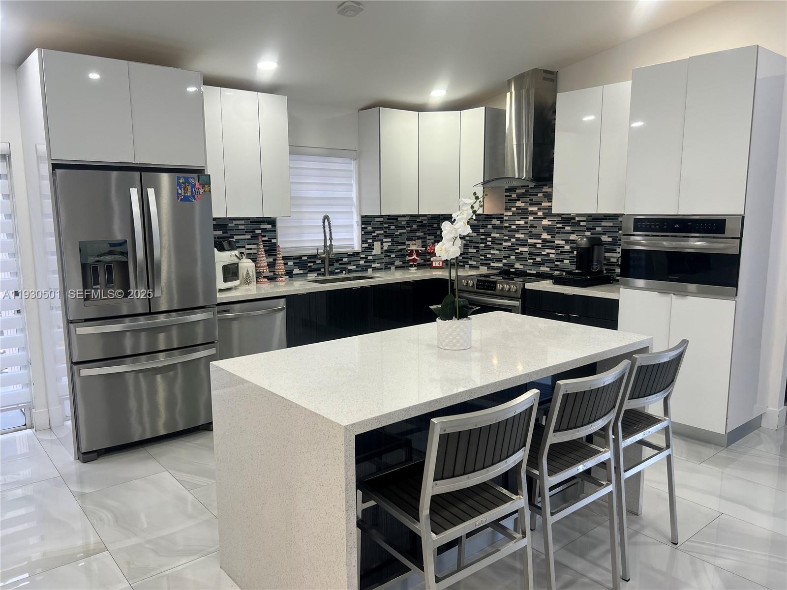 6101 Southwest 153rd Court Road Miami, FL 33193 - Photo 40 of 49 a kitchen with kitchen island a counter space a sink appliances and cabinets
