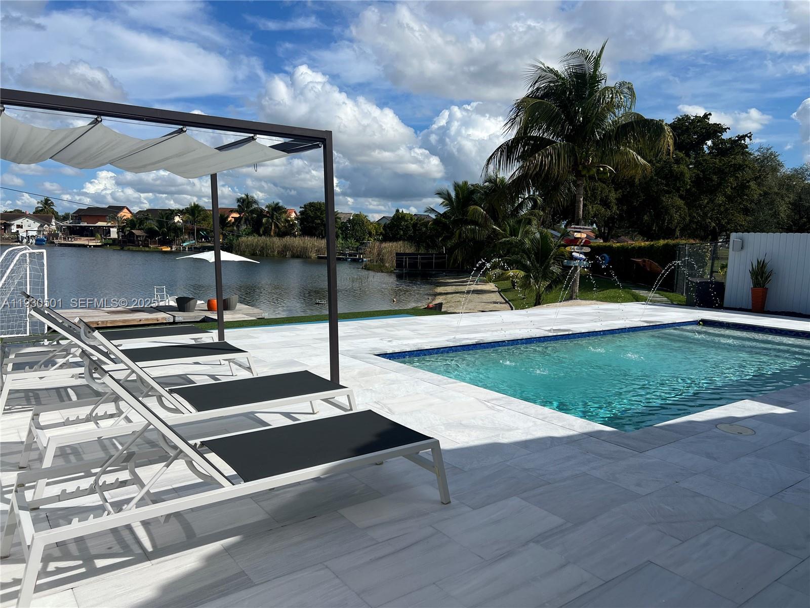 6101 Southwest 153rd Court Road Miami, FL 33193 - Photo 4 of 49 a swimming pool with some trees in the background