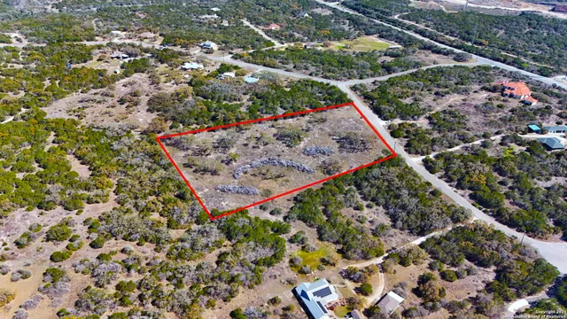 an aerial view of a house with a yard and lake view