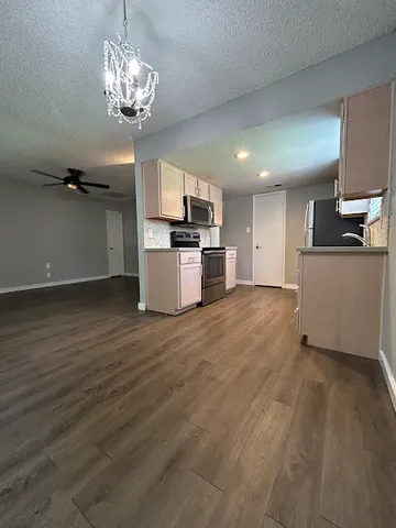 a view of a kitchen with a sink a refrigerator and window