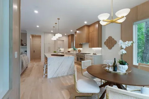 a dining room with furniture a chandelier and wooden floor