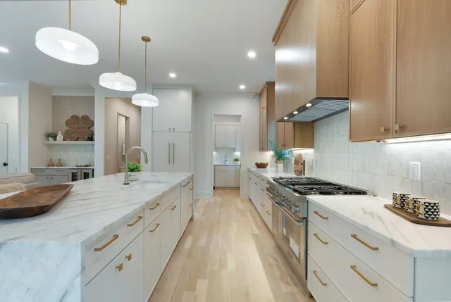 a large kitchen with kitchen island a large island in it