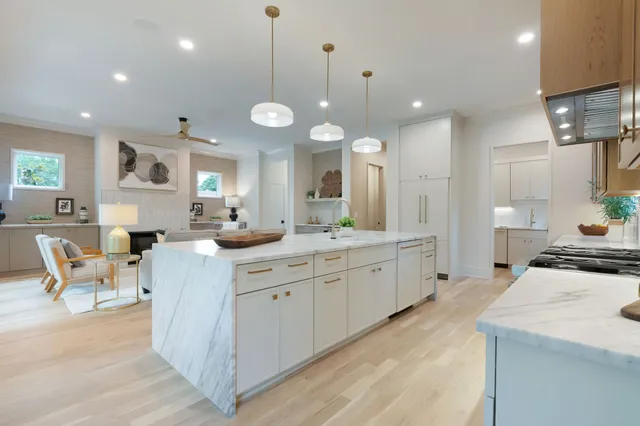 a large kitchen with kitchen island a large counter space a sink stainless steel appliances and furniture