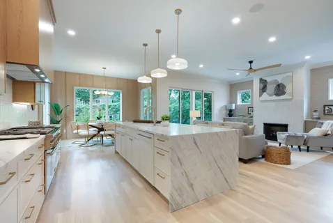 a large kitchen with kitchen island a large counter space a sink appliances and a window