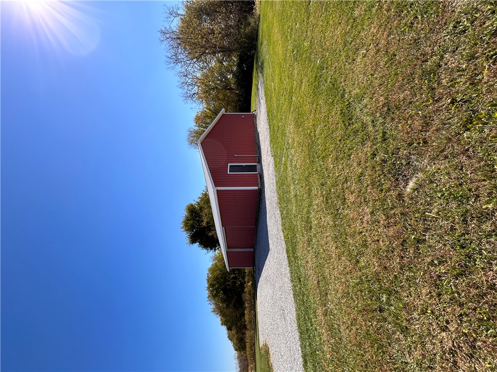 2086 Scheyhing Road Lewisburg, OH 45338 - Photo 23 of 29 A vibrant red barn stands proudly against a clear blue sky, framed by lush green grass.