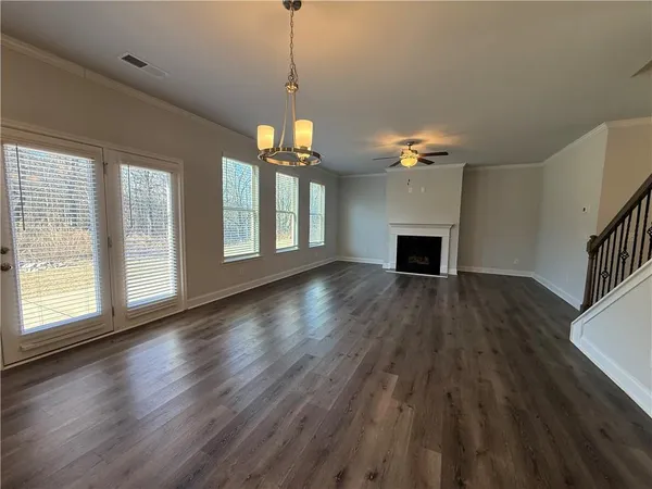 a view of a livingroom with a fireplace wooden floor and chandelier