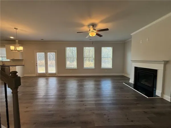 a view of an empty room with a fireplace and a window