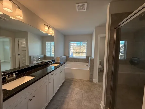 a large bathroom with a tub double sink and mirror