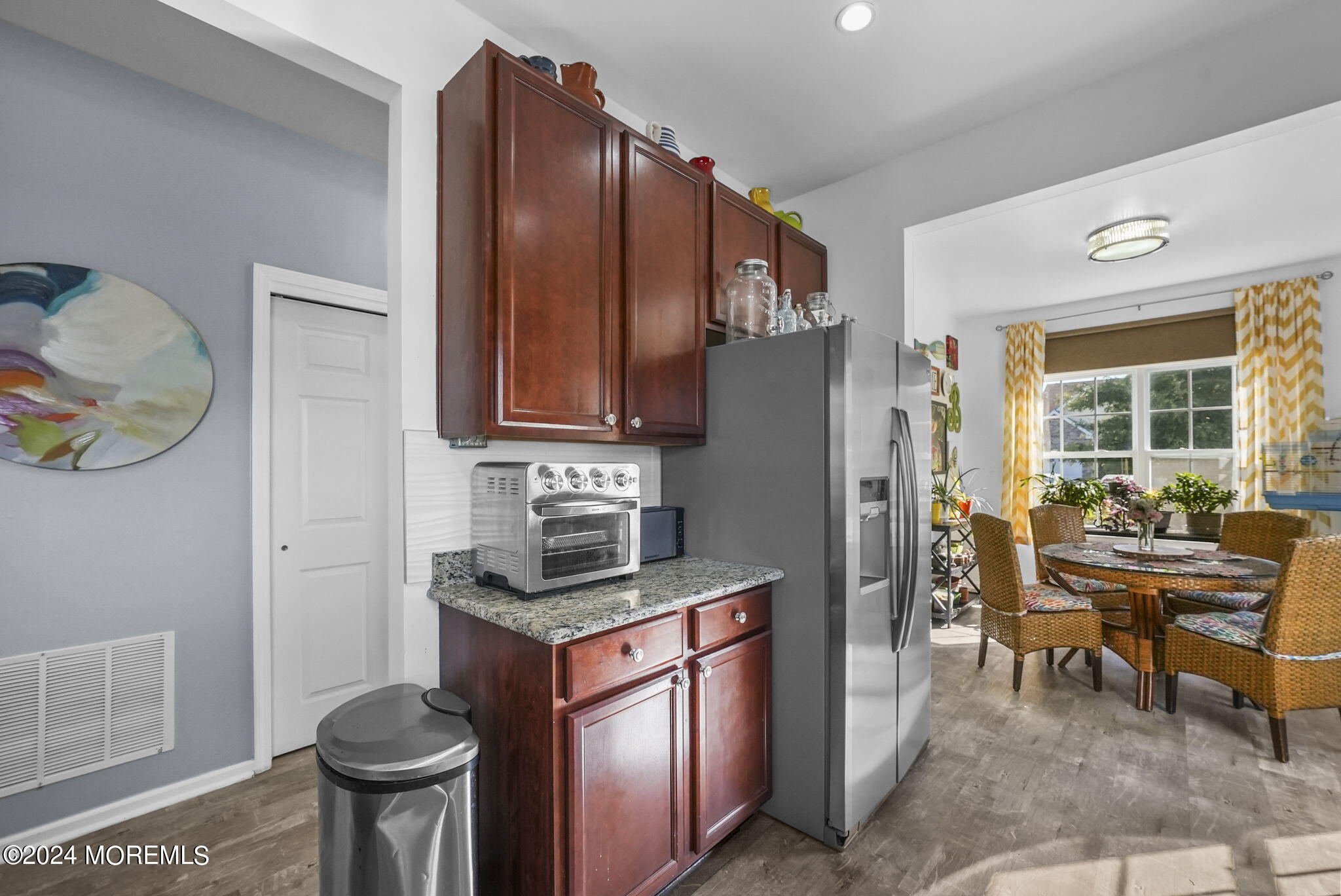 30 Silver Maple Lane Howell, NJ 07731 - Photo 7 of 43 a kitchen with stainless steel appliances granite countertop a stove refrigerator a dining table and chairs with wooden floor