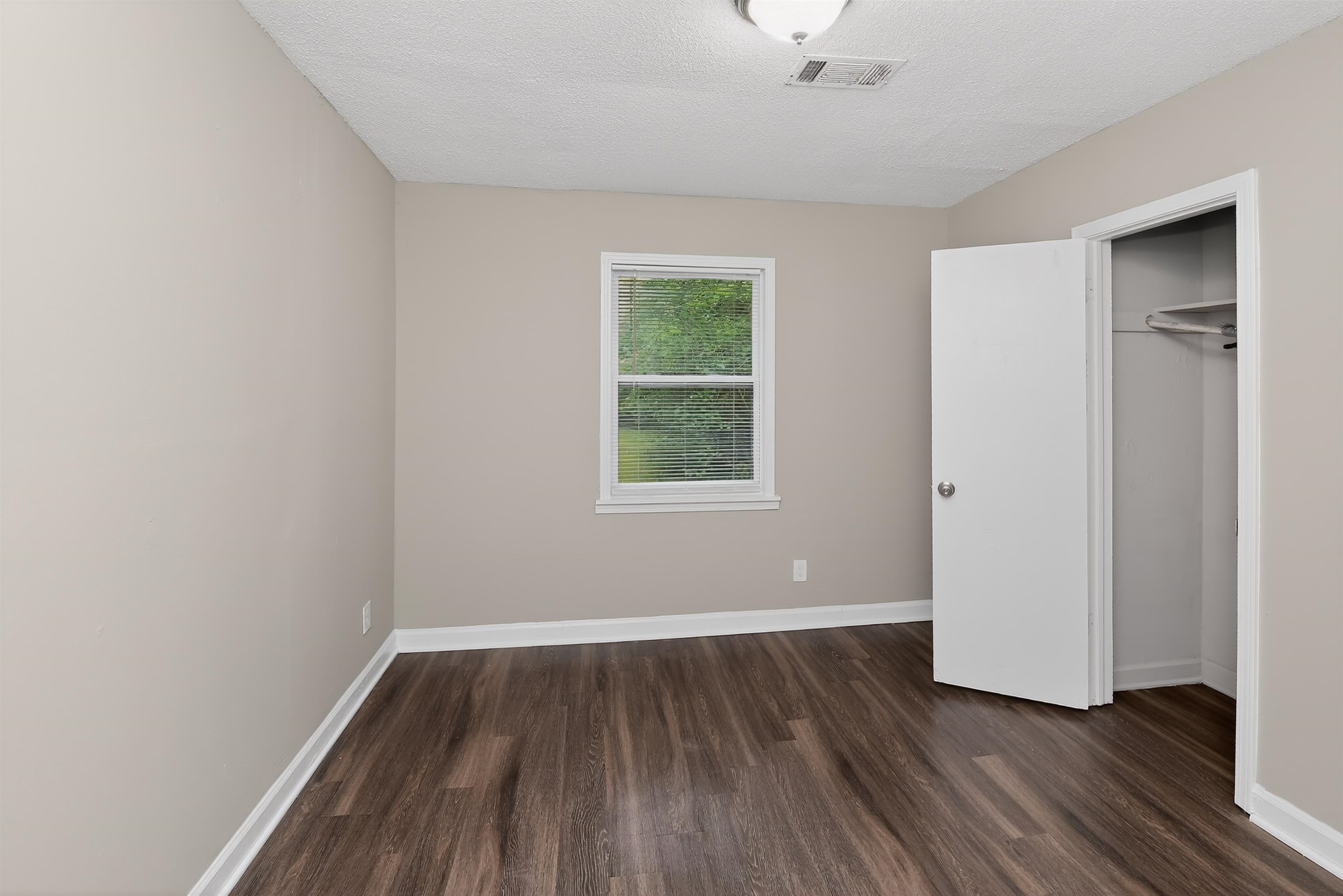 318 East Raines Road Memphis, TN 38109 - Photo 24 of 28 Room featuring wood-finish flooring, neutral wall paint, white trim, a single window, and a closet with an open door
