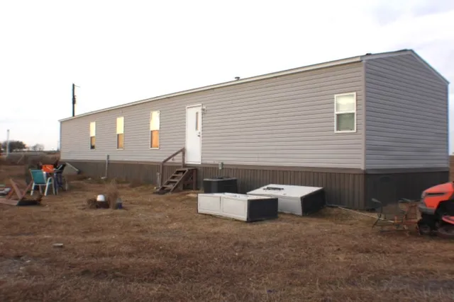 a backyard of a house with sofas fire pit and outdoor seating