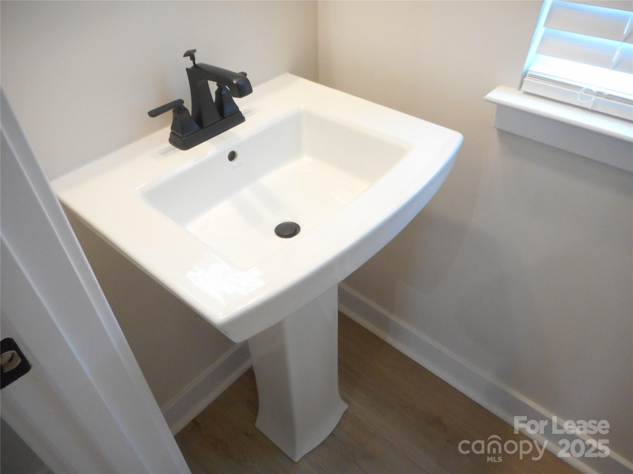 3033 Matthews-Indian Trail Road Matthews, NC 28104 - Photo 13 of 30 a bathroom with a sink and white cabinets