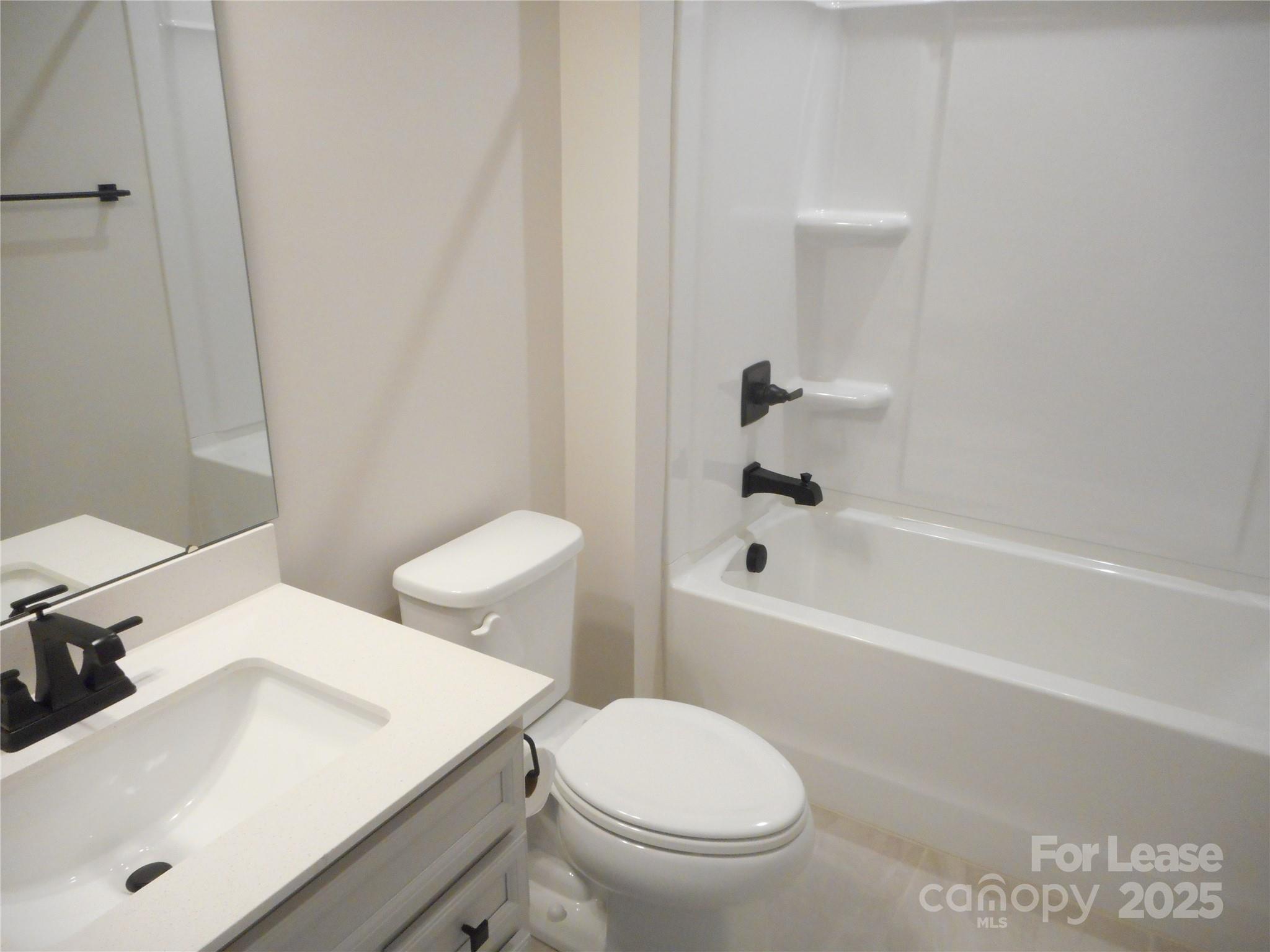 3033 Matthews-Indian Trail Road Matthews, NC 28104 - Photo 20 of 30 a white toilet sitting next to a bathroom sink