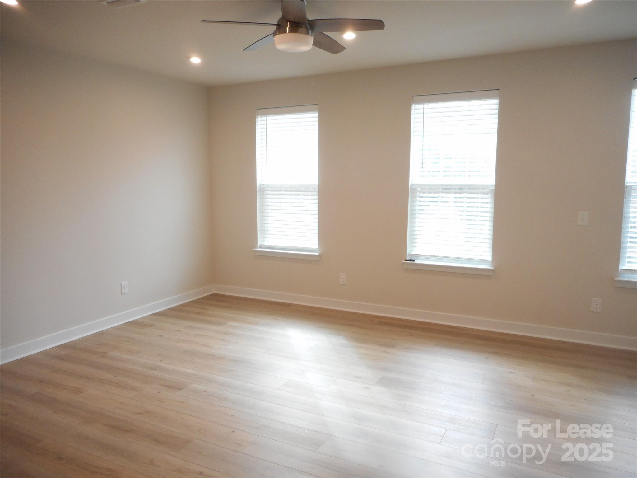 3033 Matthews-Indian Trail Road Matthews, NC 28104 - Photo 10 of 30 an empty room with wooden floor and windows
