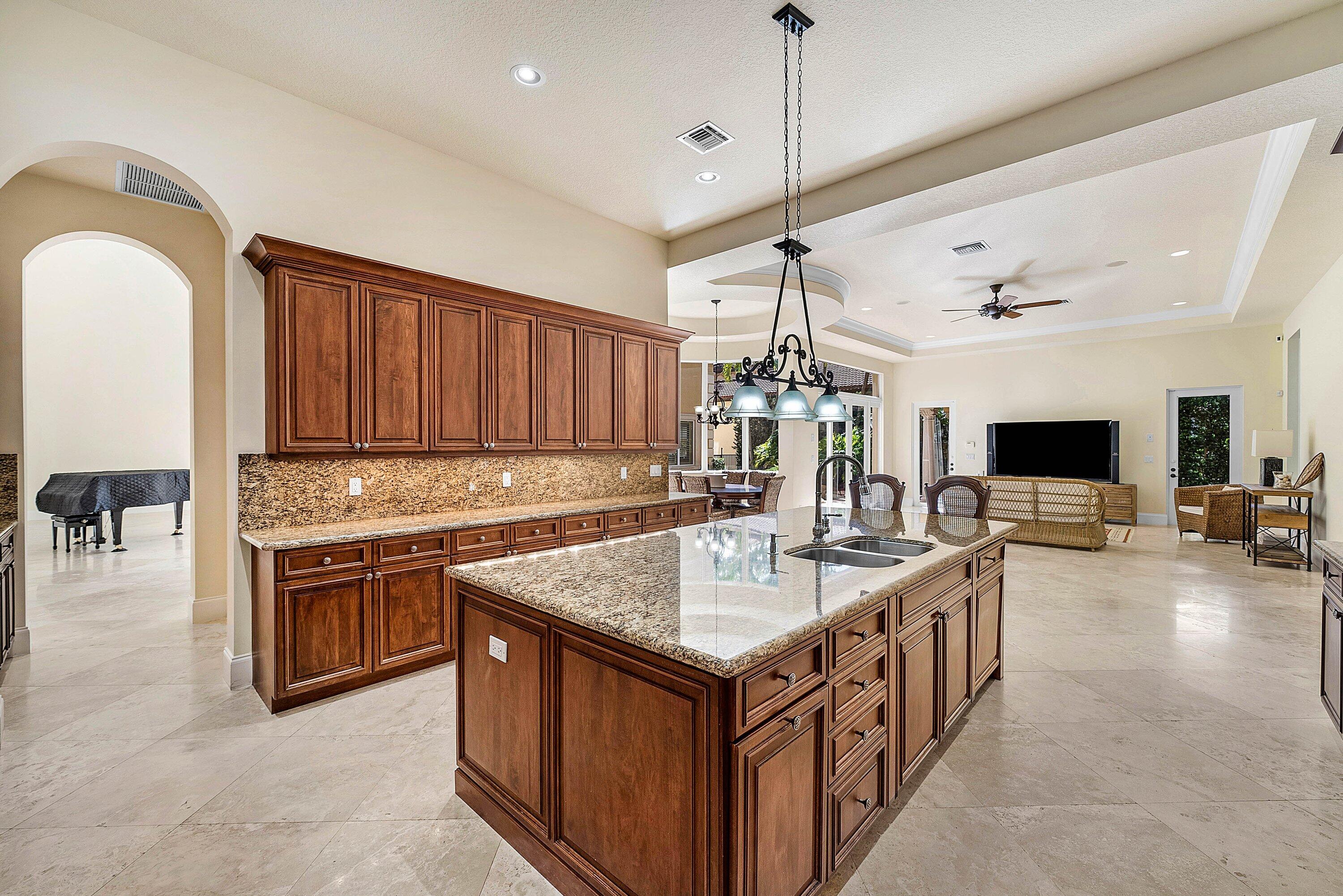 17387 Balaria Street Boca Raton, FL 33496 - Photo 22 of 65 a kitchen with kitchen island a sink stove and a refrigerator with wooden floor