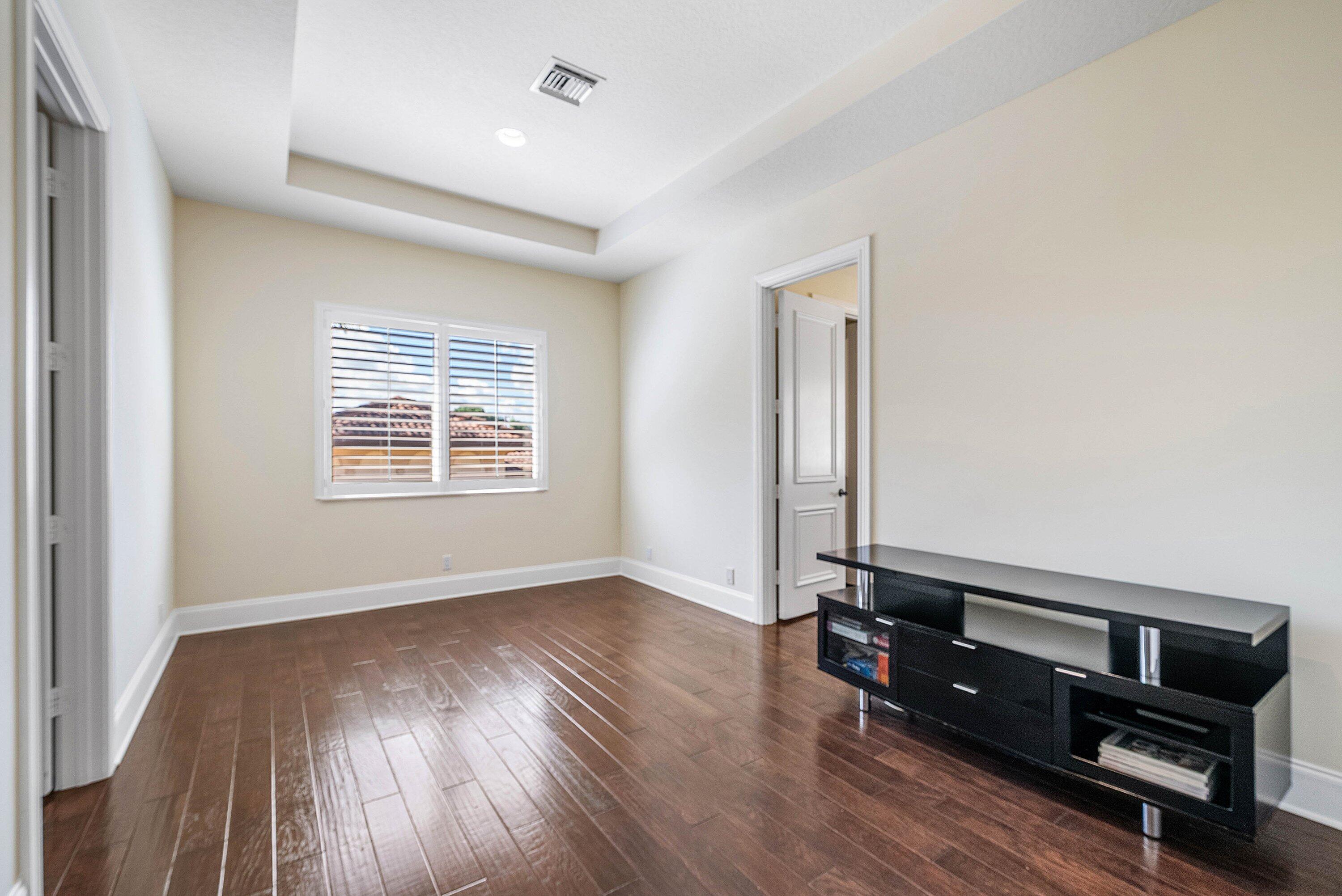 17387 Balaria Street Boca Raton, FL 33496 - Photo 50 of 65 an empty room with wooden floor and windows