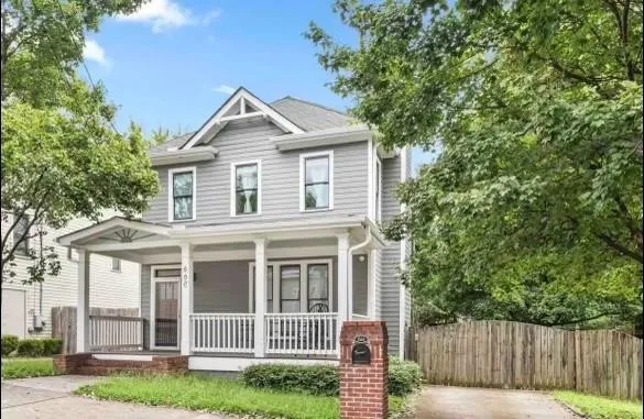 a view of a house with a small yard and wooden fence