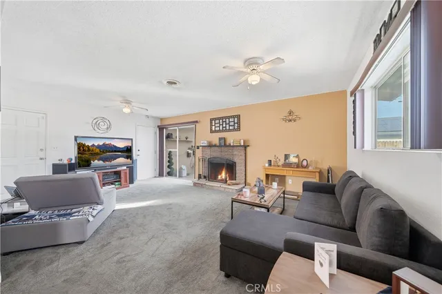 a living room with furniture a fireplace and a large window