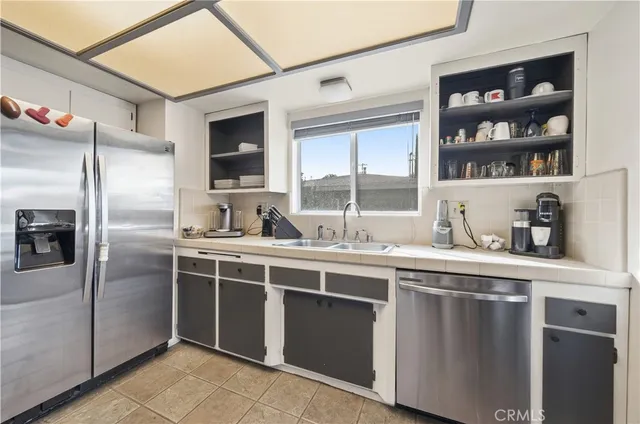 a kitchen with stainless steel appliances granite countertop a sink and a refrigerator