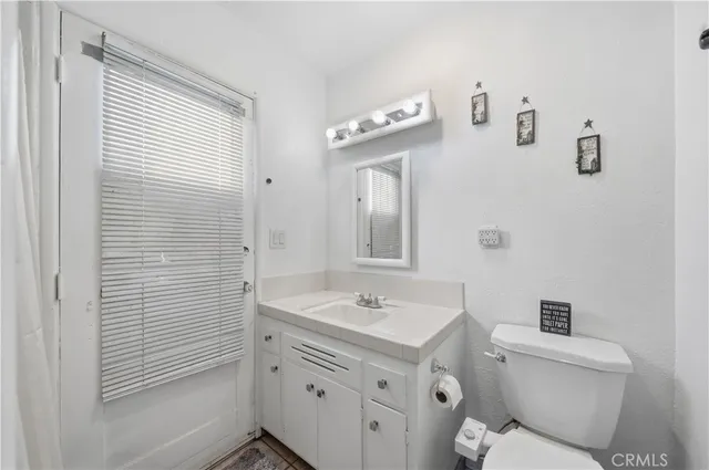 a bathroom with a sink a toilet and shower curtain