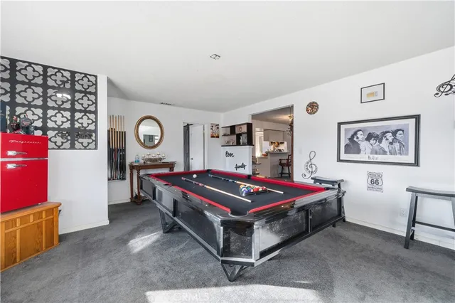 a living room with a bed furniture and paintings on the wall