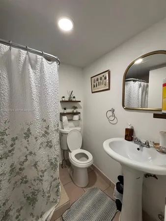 a bathroom with a sink toilet and a mirror