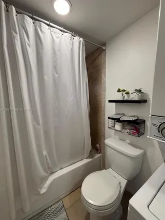 a white toilet sitting next to a shower curtain