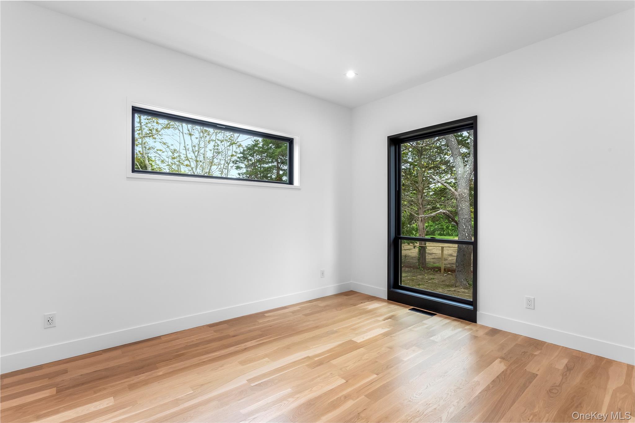 600 Glenn Road Southold, NY 11971 - Photo 11 of 22 an empty room with wooden floor and windows