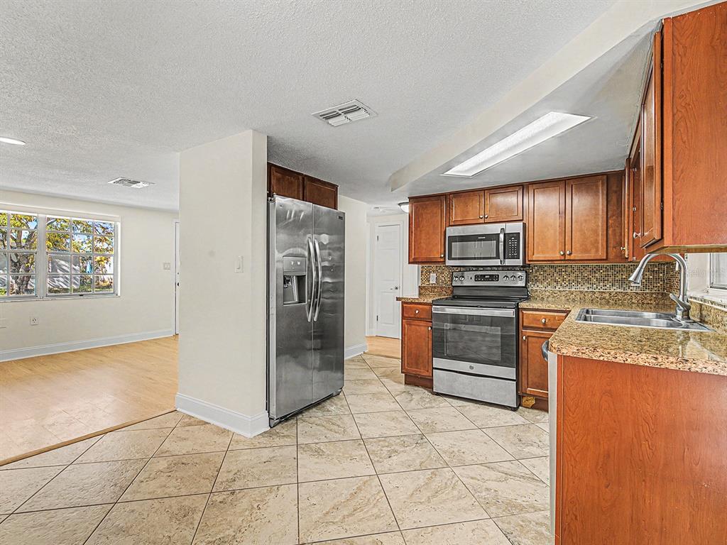 9430 Gray Fox Lane Port Richey, FL 34668 - Photo 11 of 33 a kitchen with stainless steel appliances granite countertop a refrigerator and a stove top oven