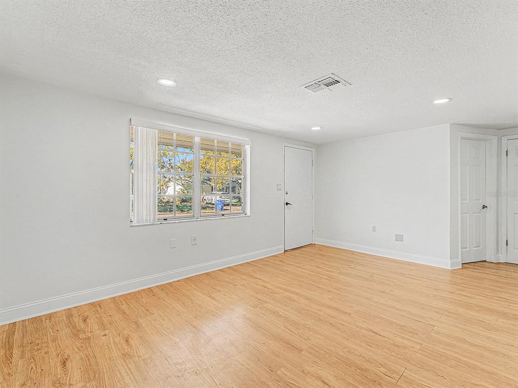 9430 Gray Fox Lane Port Richey, FL 34668 - Photo 16 of 33 wooden floor in an empty room with a window