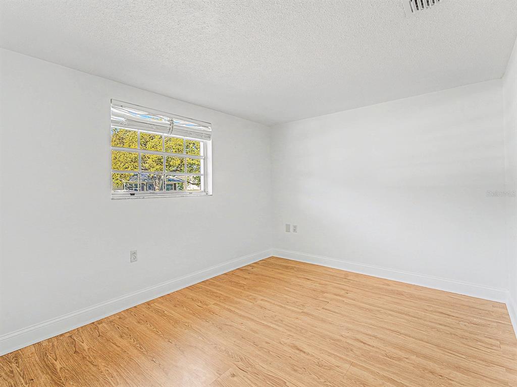 9430 Gray Fox Lane Port Richey, FL 34668 - Photo 18 of 33 an empty room with wooden floor and a window