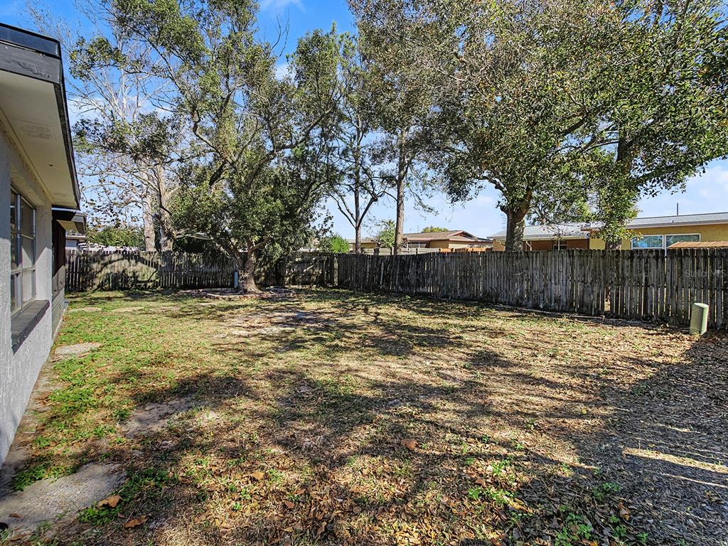 9430 Gray Fox Lane Port Richey, FL 34668 - Photo 25 of 33 a view of a backyard with large trees and wooden fence
