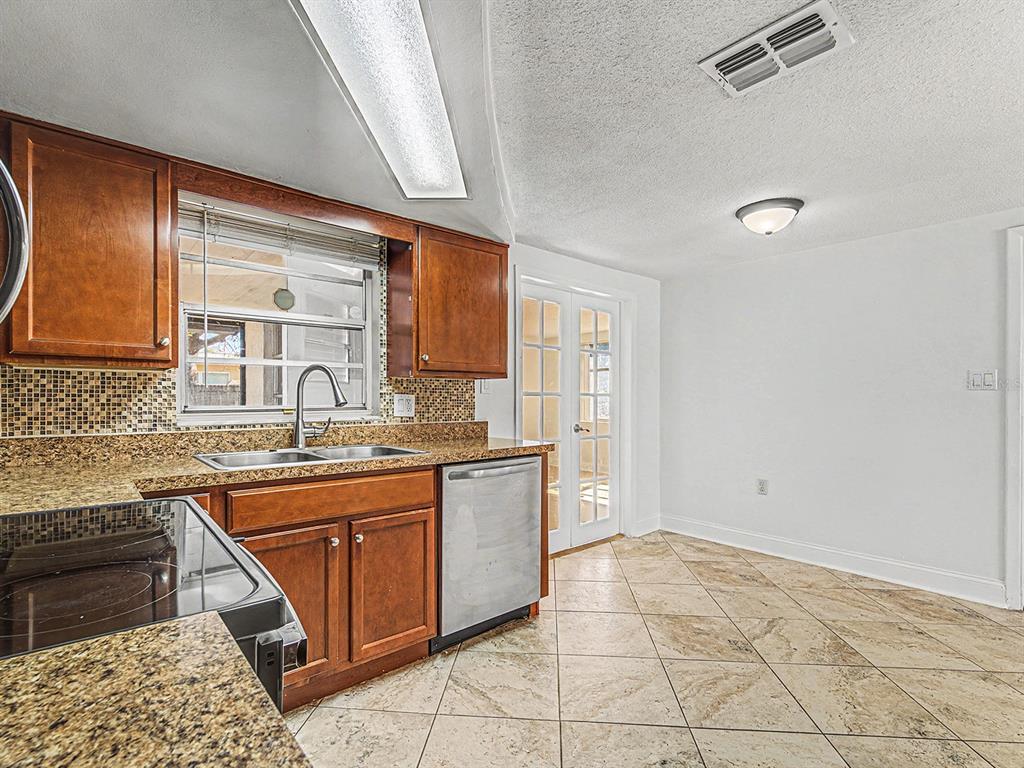 9430 Gray Fox Lane Port Richey, FL 34668 - Photo 9 of 33 a kitchen with stainless steel appliances granite countertop a sink and cabinets