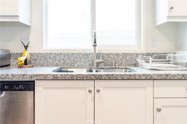 a kitchen with granite countertop a sink stove and refrigerator