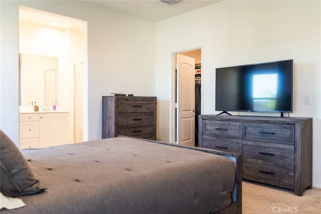 a bedroom with a bed a desk and a window