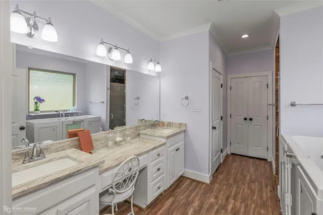 a spacious bathroom with a granite countertop double vanity sink a mirror and shower