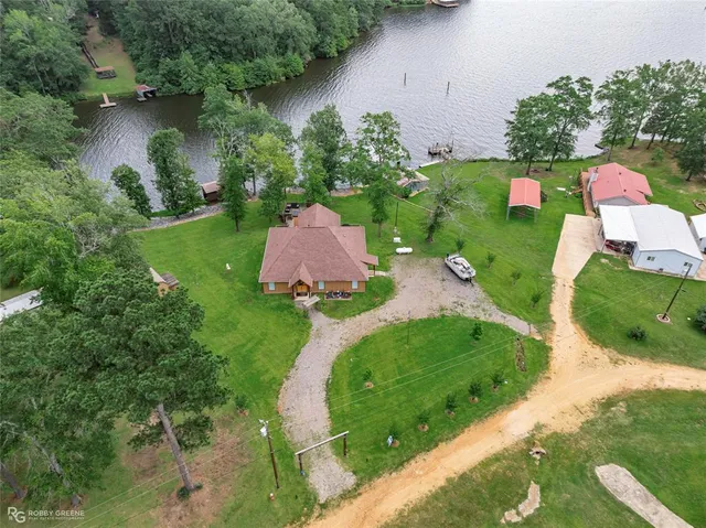 an aerial view of a house with a yard and lake view