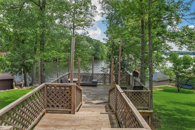 a view of a roof deck with couches and wooden fence