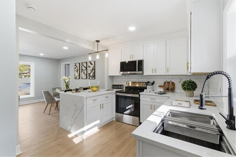 4015 Moffat Court Decatur, GA 30035 - Photo 8 of 34 a kitchen with granite countertop a stove top oven sink and cabinets