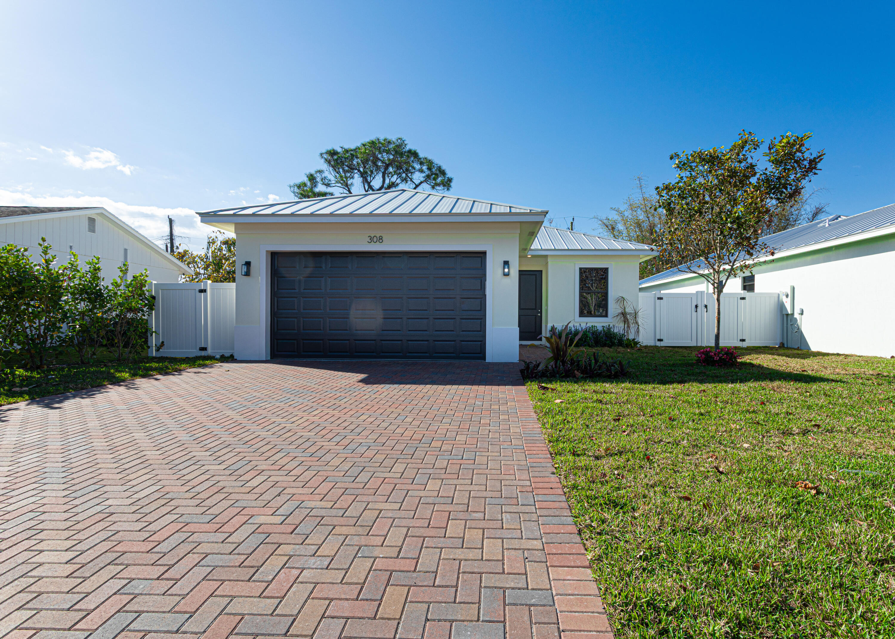 308 4th Street Jupiter, FL 33458 - Photo 1 of 51 a front view of a house with a yard and a garage